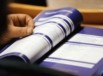 Person browsing conference programme booklet