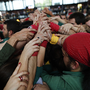 People gathered round clasping their hands up in the air
