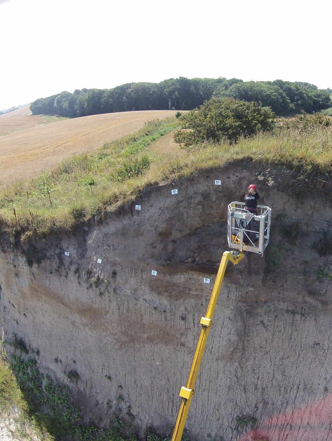 Archaeologist in a lift basket investigating a Bronze Age barrow