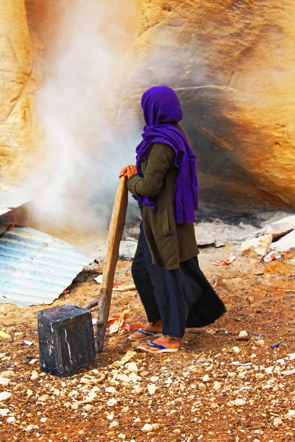 Woman looking-away from the camera, standing at an archaeological site in the Middle East.